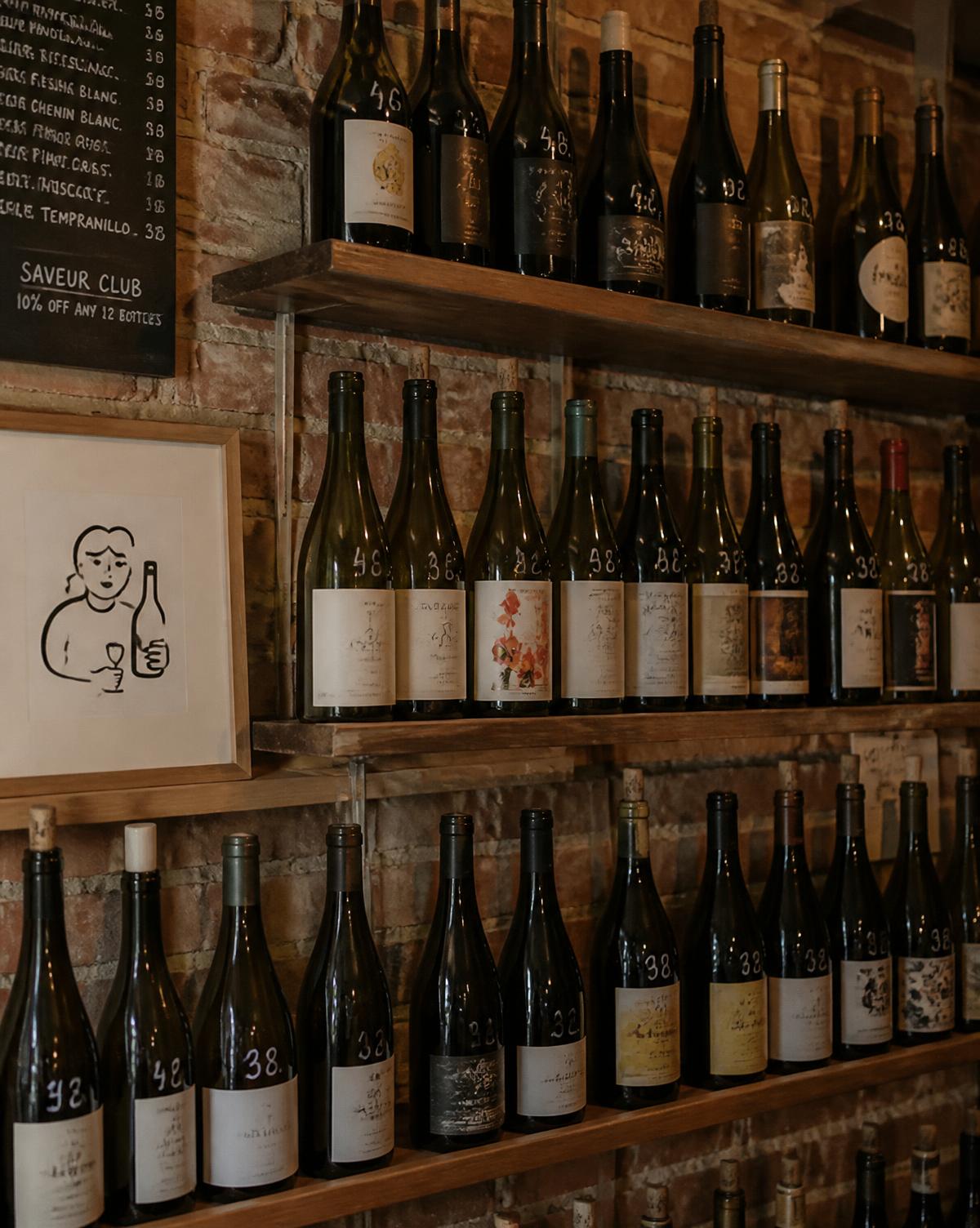 Estantes de madera con botellas de vino natural sobre pared de ladrillo en El Lobo